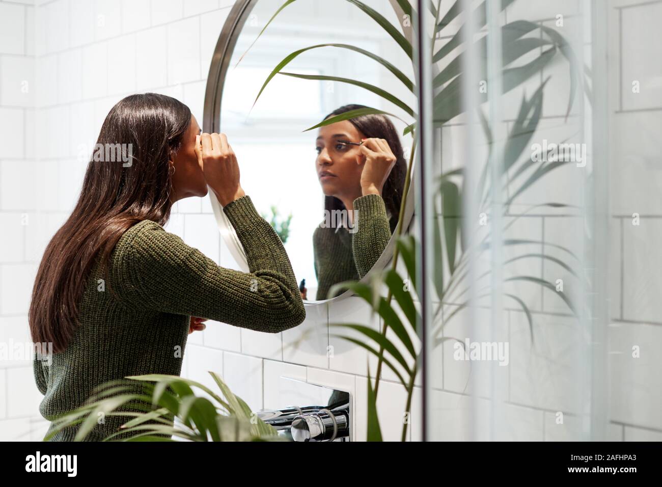 Businesswoman At Home mise sur composent en miroir avant de quitter pour le travail Banque D'Images