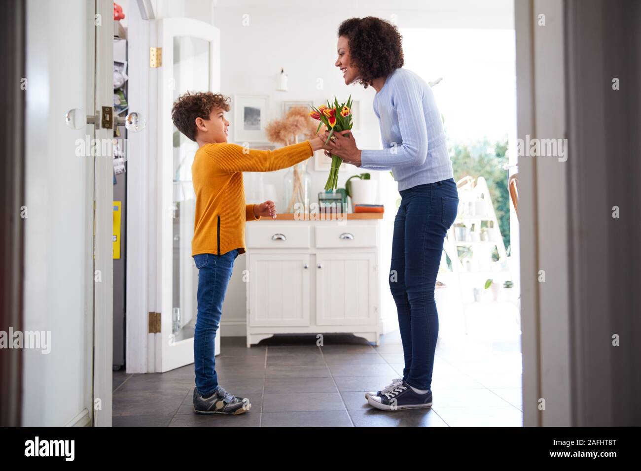 Fils aimant donner mère Bouquet de fleurs pour célébrer la Fête des mères à la maison Banque D'Images