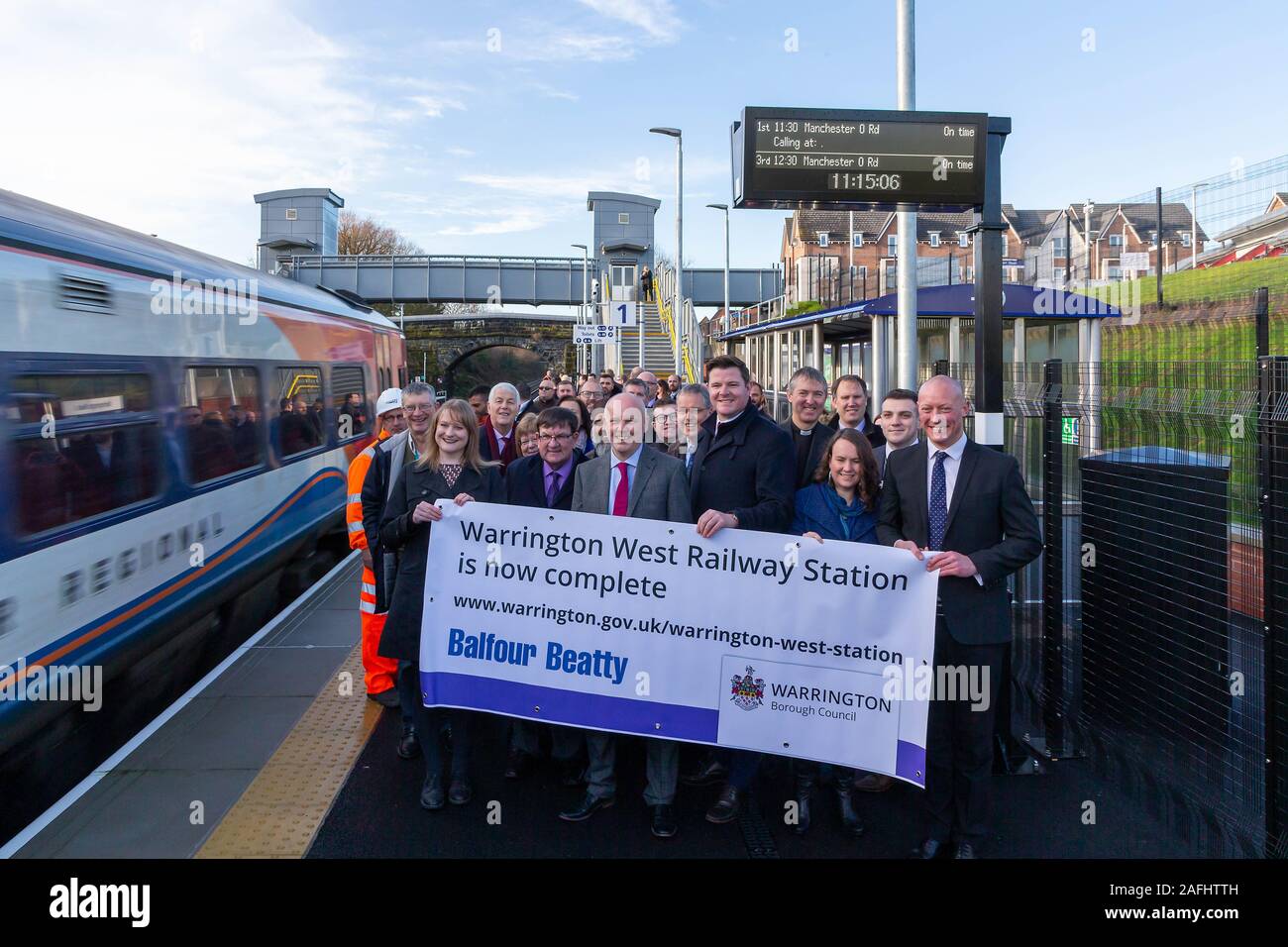 Warrington, Cheshire, Royaume-Uni. Dec 16, 2019. L'ouverture officielle de la gare de l'ouest de Warrington. Tenir une dignitaires bannière sur la plate-forme de la gare de l'ouest de Warrington, Chapelford, Warrington, Cheshire, Angleterre comme la vitesse des trains par l'intermédiaire de la station Crédit : John Hopkins/Alamy Live News Crédit : John Hopkins/Alamy Live News Banque D'Images