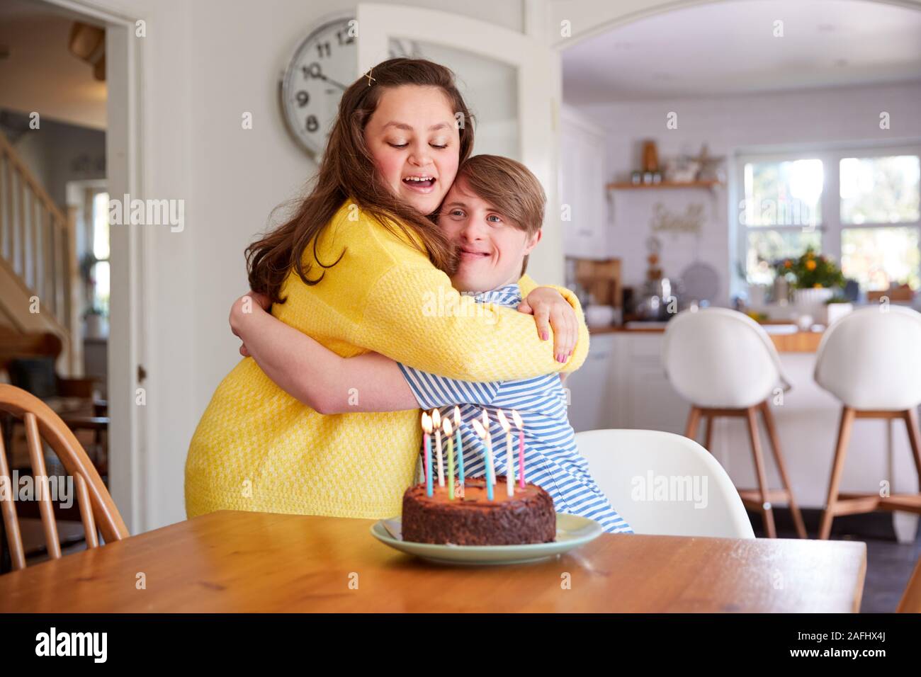 Les jeunes couples célébrant le syndrome de Down à la maison d'anniversaire avec gâteau Banque D'Images