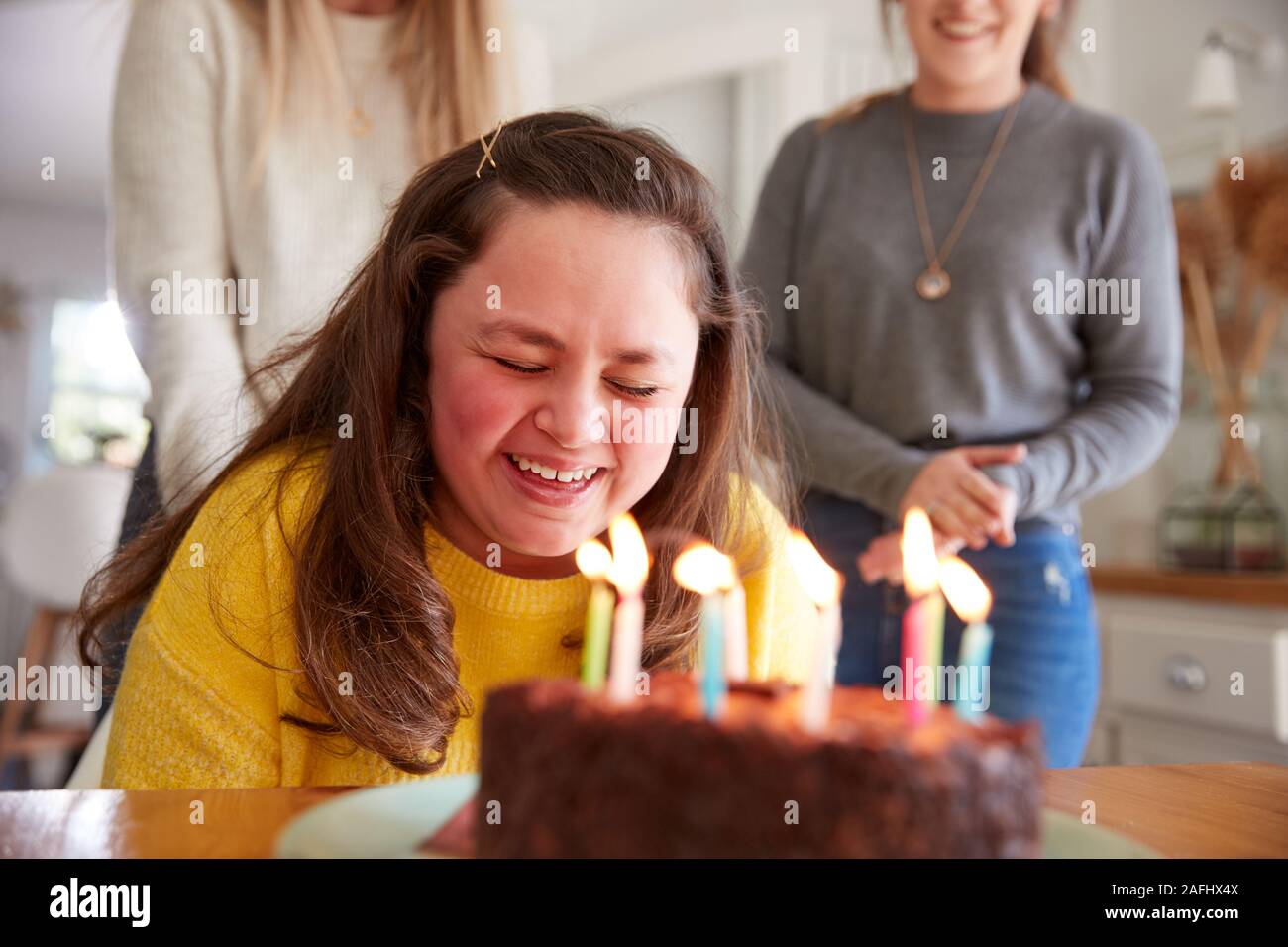 Jeune femme Trisomie célébrer anniversaire à la maison avec du gâteau Banque D'Images