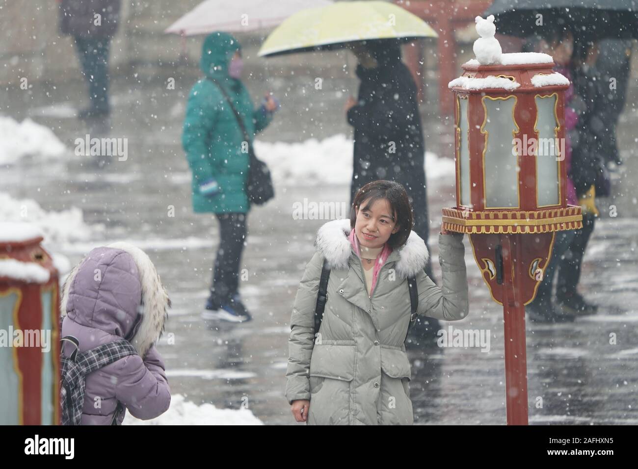 Beijing, Chine. Dec 16, 2019. Une femme pose pour des photos à l'Tiantan (Temple du Ciel) Park à Beijing, capitale de la Chine, 16 décembre 2019. Une chute de neige a frappé Beijing lundi. Credit : Ju Huanzong/Xinhua/Alamy Live News Banque D'Images