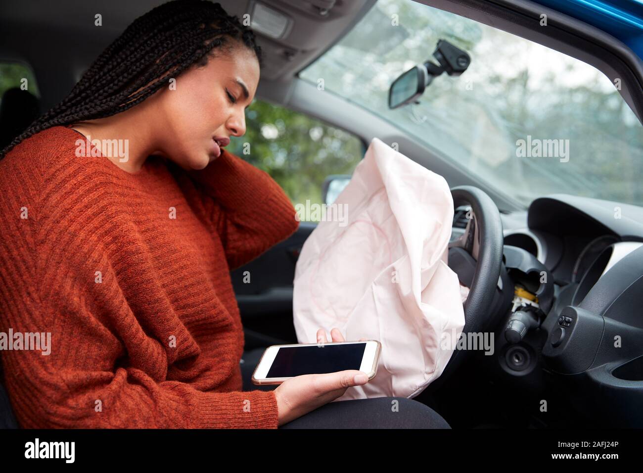 Automobiliste femelle blessé dans un accident de voiture après l'utilisation de téléphone mobile pendant la conduite Banque D'Images