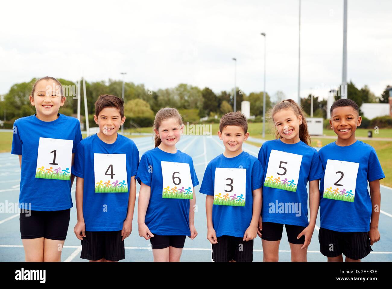 Portrait d'enfants sur piste d'athlétisme portant des numéros de concurrents sur la Journée des sports Banque D'Images