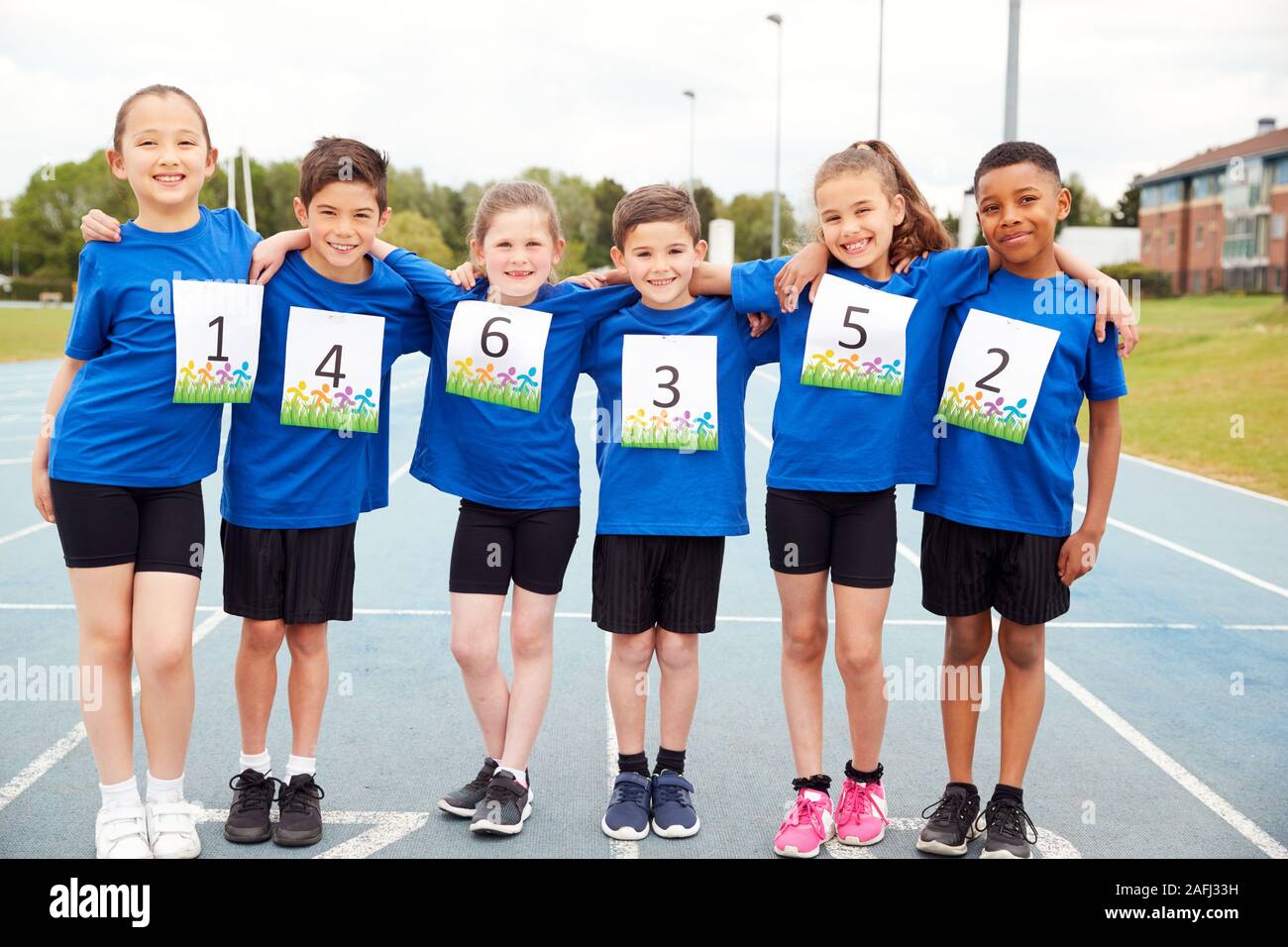 Portrait d'enfants sur piste d'athlétisme portant des numéros de concurrents sur la Journée des sports Banque D'Images