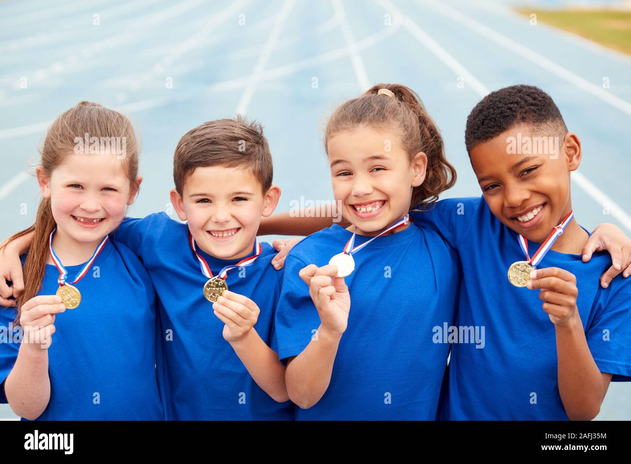Portrait d'enfants montrant outre de gagnants de médailles sur la Journée des sports Banque D'Images