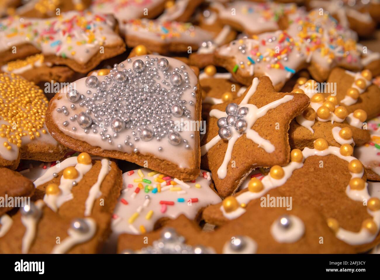 De nombreux faits main colorés gingerbread cookies au four et décorée pour Noël. Boules d'argent et d'or sur the go glacé dans différentes formes Banque D'Images