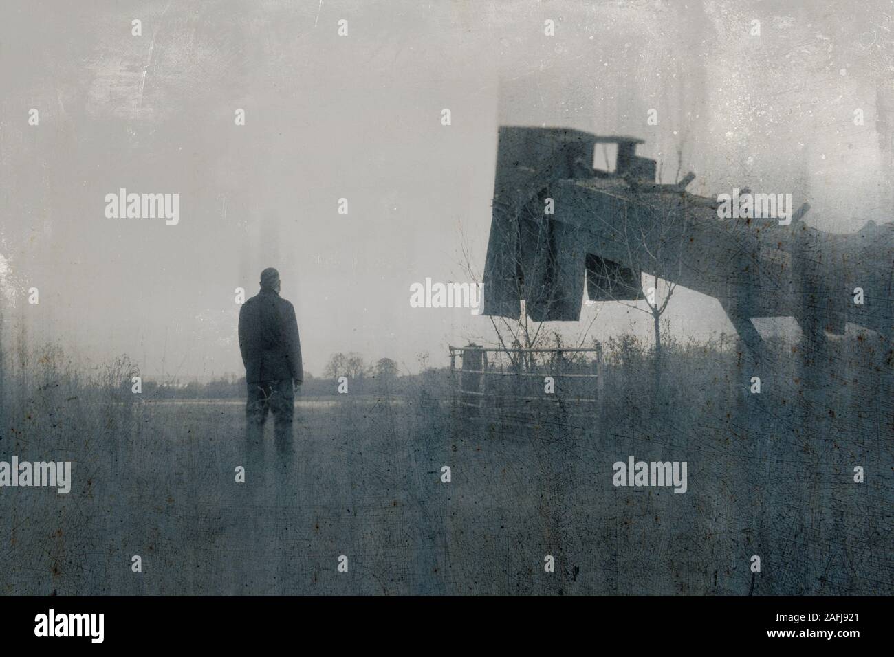 Un sombre, Moody, winters jour d'une figure masculine debout à côté pour extraire de la machine dans une rubrique dans la campagne. Avec un flou, texturé, essuyé, abs Banque D'Images