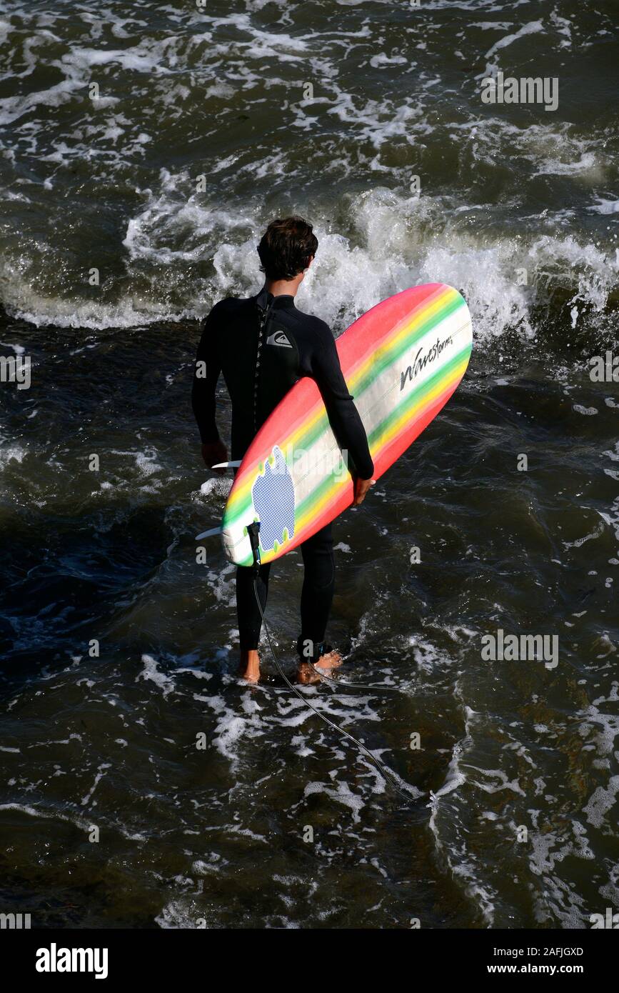 Surfer geht mit seinem Surf ins Wasser am Strand von Santa Cruz, Kalifornien, USA Banque D'Images