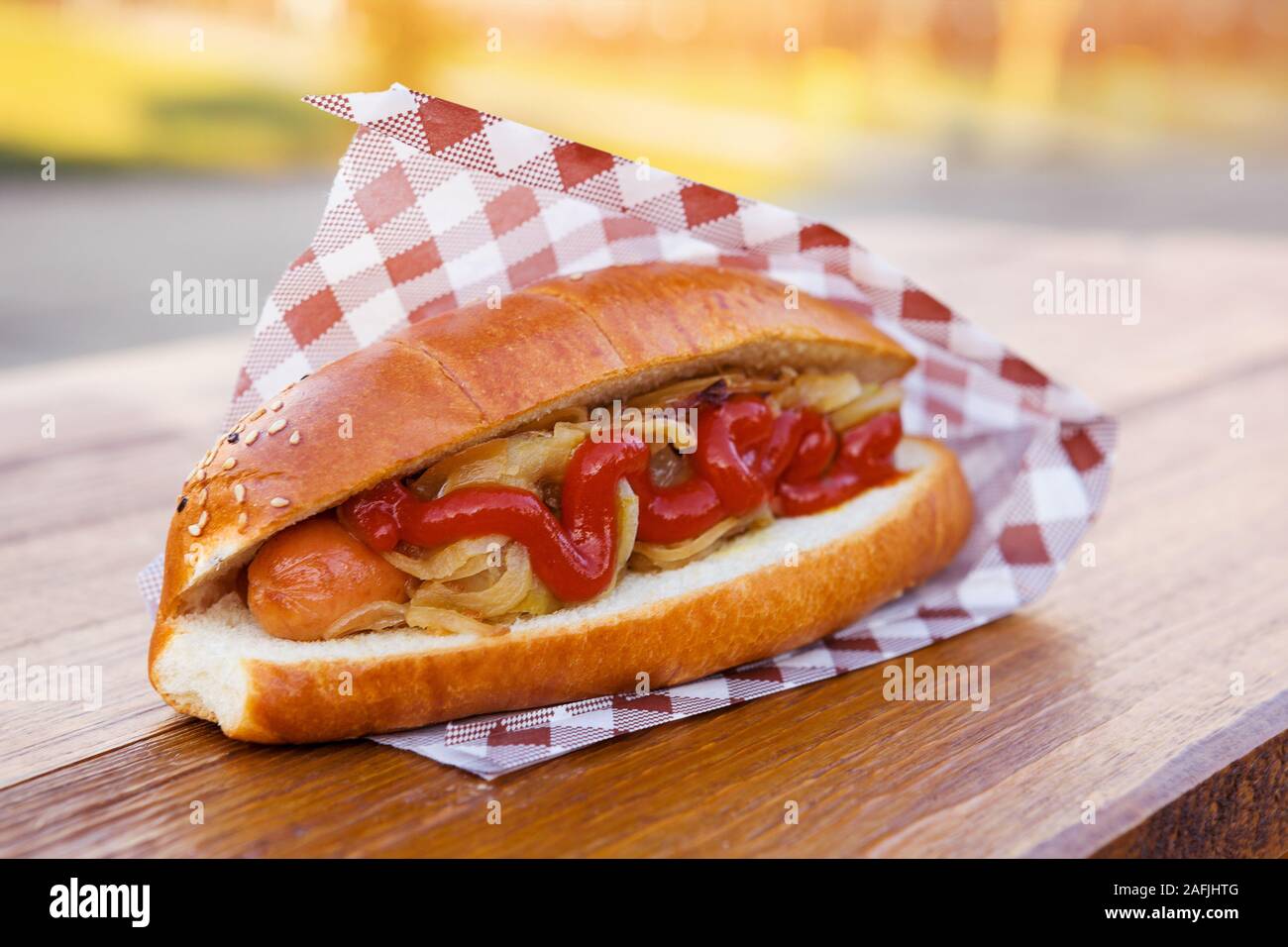 American sandwich hot-dog avec de la saucisse, l'oignon et de la sauce. La nourriture à emporter. Banque D'Images