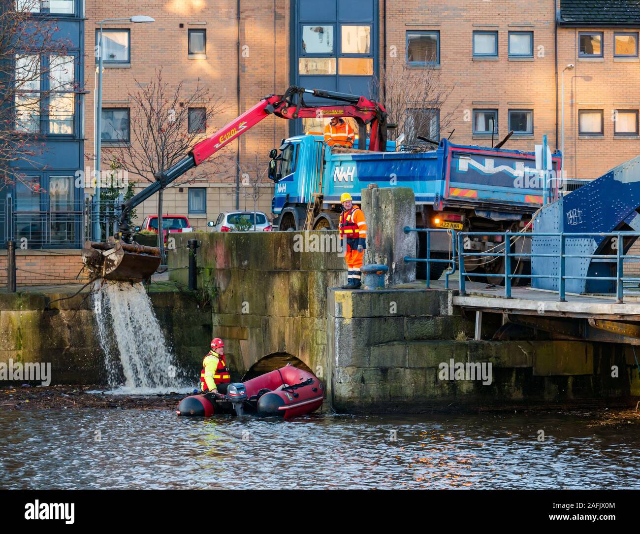Nettoyage des débris et déchets dans l'eau de Leith river par hommes travaillant à la pneumatique à coque rigide & camion avec grue, Édimbourg, Écosse, Royaume-Uni Banque D'Images