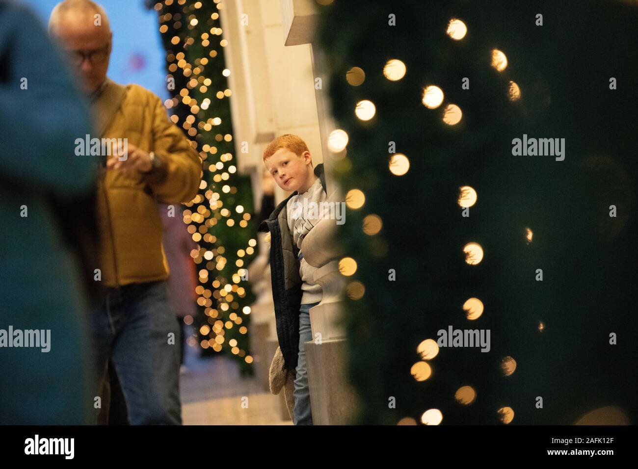 Petit garçon cheveux gingembre tenant un grand soft toy bunny en dehors de Selfridges. Lumières de Noël et décorations dans l'arrière-plan. Londres Banque D'Images