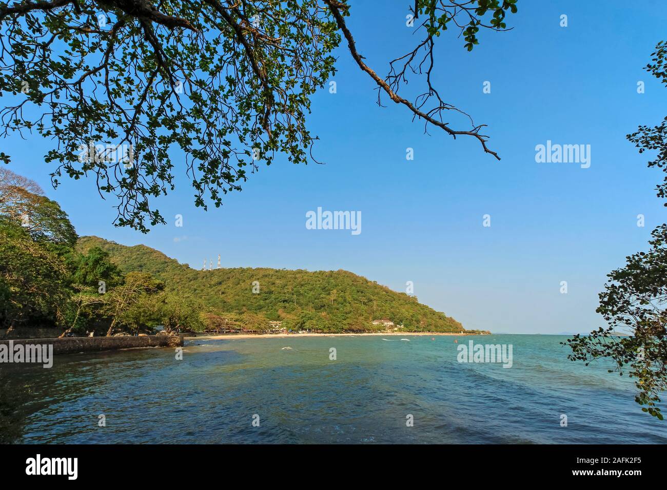 La baie verdoyante de la populaire plage de Kep avec la forêt du parc national derrière, dans cette paisible ancienne ville de villégiature française du sud; Kep, province de Kep, Cambodge Banque D'Images