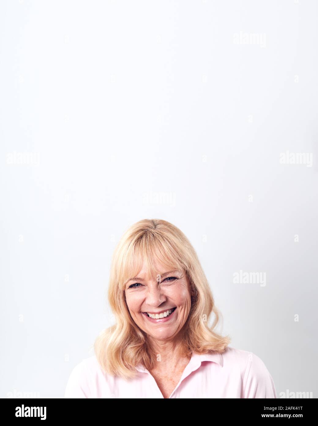 Portrait Of Smiling Mature Woman Against White Background at Camera Banque D'Images