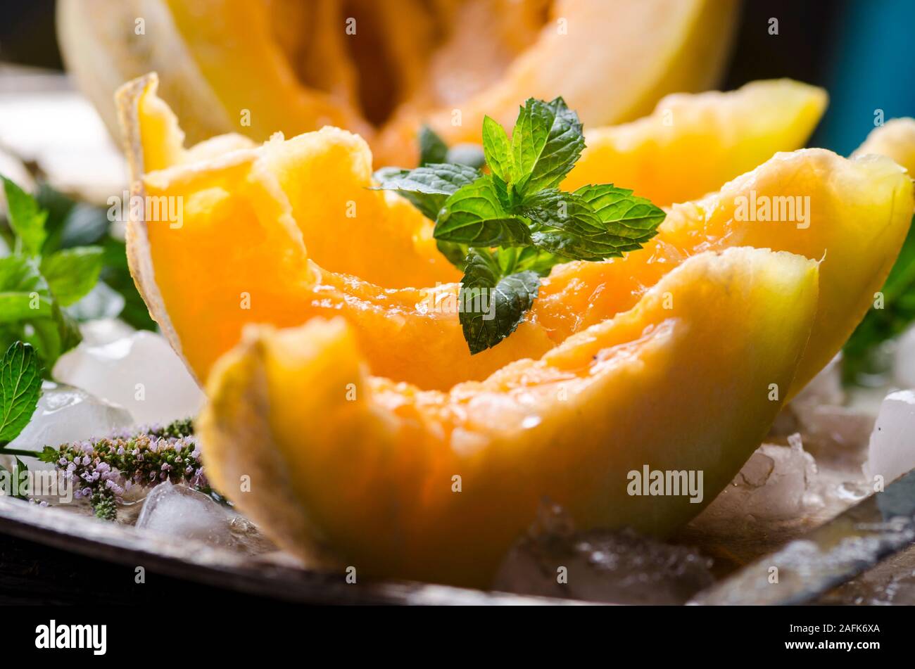 Libre de tranches de melon cantaloup à la menthe et de la glace servie sur la plaque d'argent vintage. Fruit sucré dessert toujours la vie. Banque D'Images