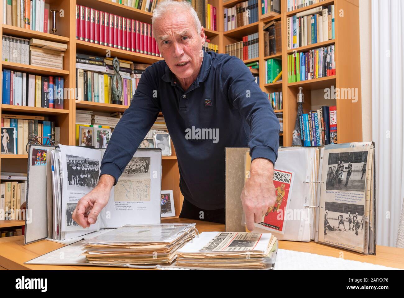 Dresde, Allemagne. Dec 16, 2019. Karl-Heinz Domschke, ancien joueur de hockey sur glace de la RDA, se tient à la maison avec des souvenirs de son étude. Il est en charge de la chronique des sports de glace en Dresde. Domschke, né en 1953, a joué pour Dresdner Eishockey-Vereine et l'équipe nationale de la RDA et recueille tout pour le hockey sur glace. Credit : Matthias Rietschel/dpa-Zentralbild/ZB/dpa/Alamy Live News Banque D'Images