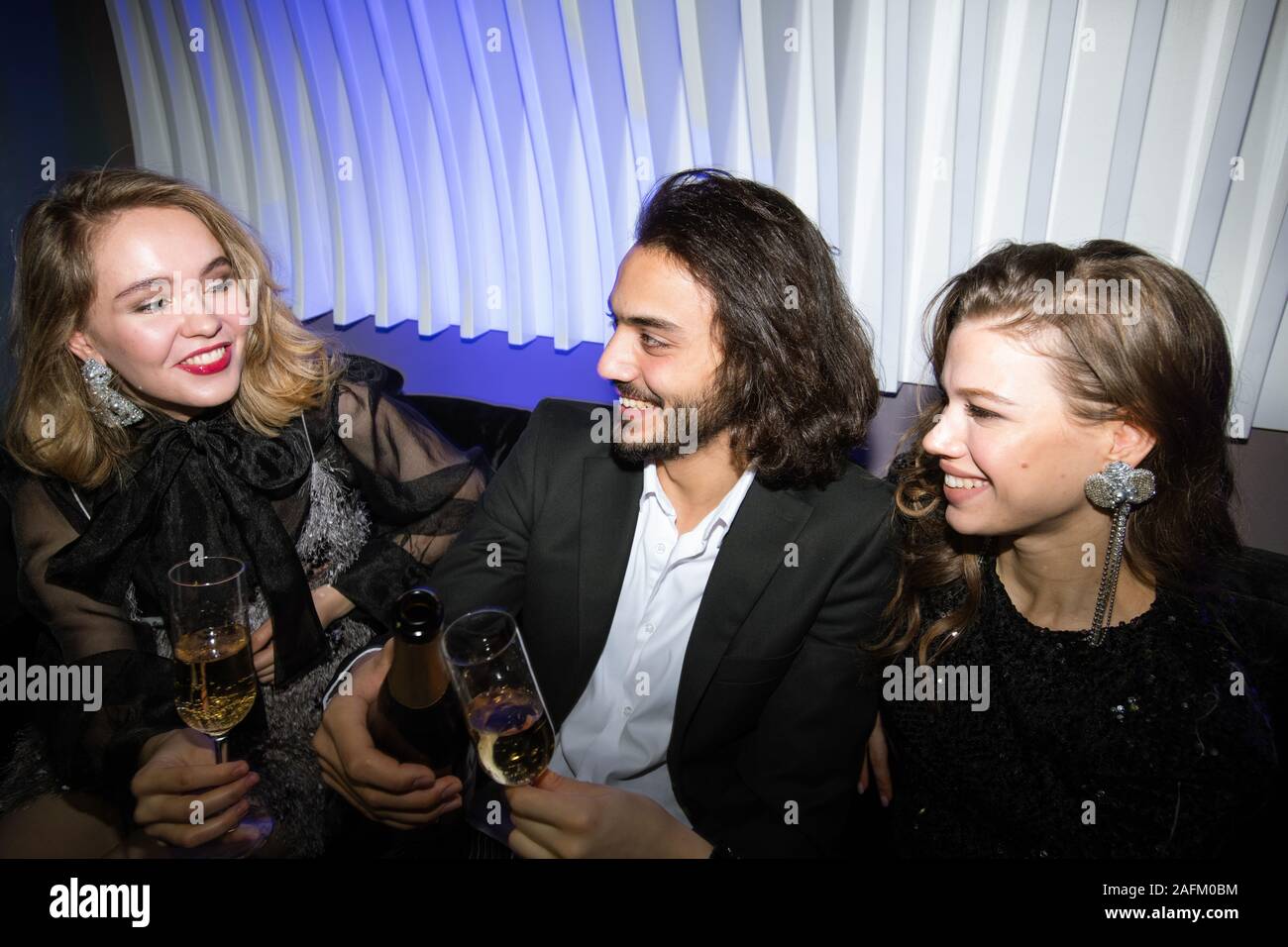 Happy gorgeous filles et jeunes homme élégant toasting with champagne Banque D'Images