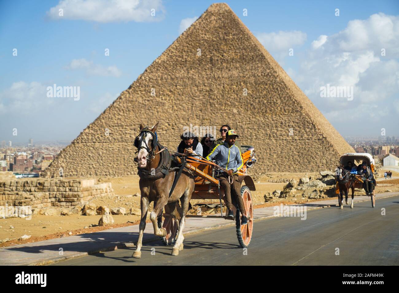 Les touristes dans un horsecart devant les pyramides de Gizeh, Le Caire, Egypte Banque D'Images