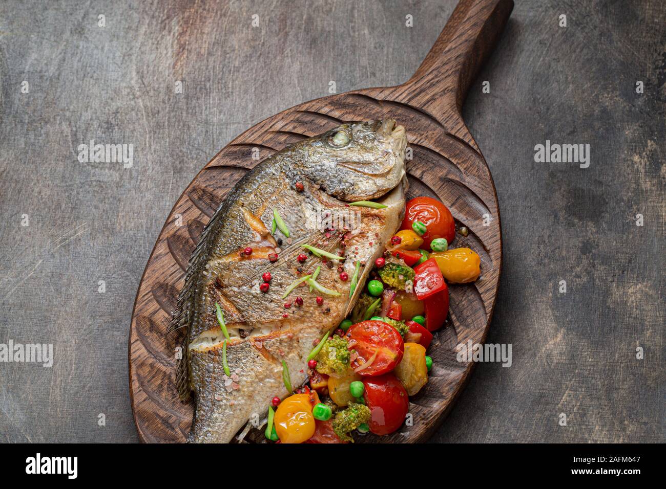 Gros plan de poisson poêlé dorado avec des légumes. Banque D'Images
