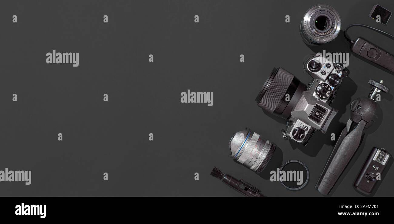 Travail avec le photographe photo reflex numérique, objectif, tablette et accessoires pour l'appareil photo sur fond noir. Appareil photo, photographie, contenu visuel concept. Télévision laïcs ou vue d'en haut. Copier l'espace. Lumière dure. Banner Banque D'Images