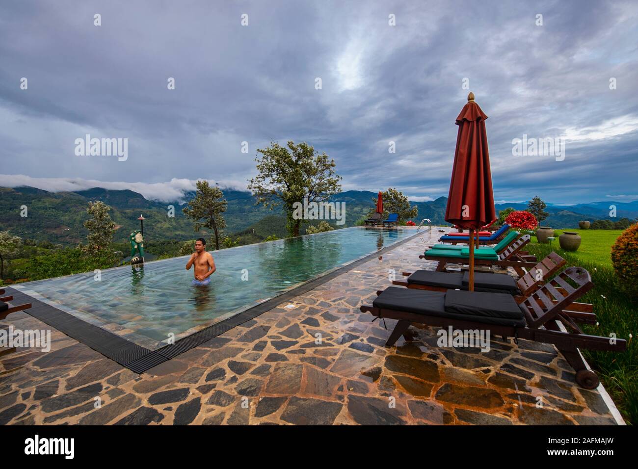 Man relaxing in swimming pool sur les hauts plateaux du centre de Sri Lanka Banque D'Images
