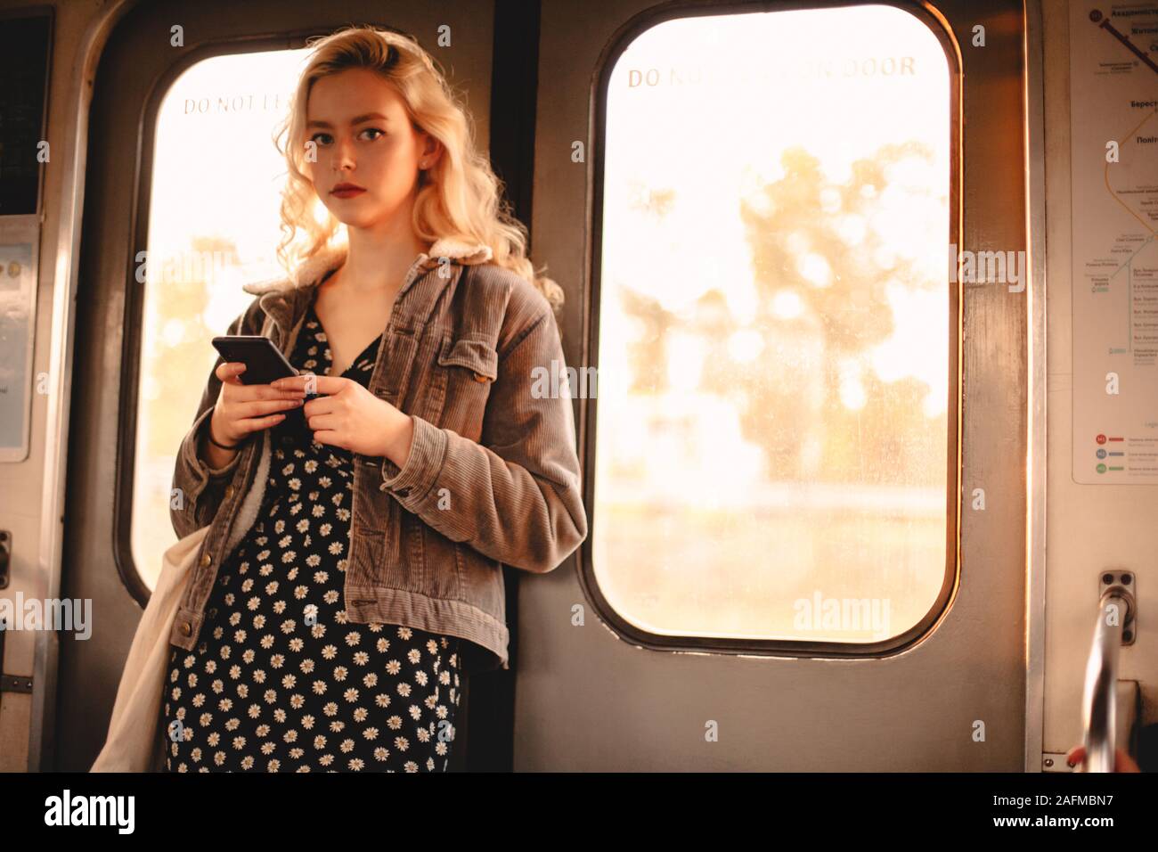 Jeune femme à l'aide de smart téléphone portable en voyage en métro Banque D'Images