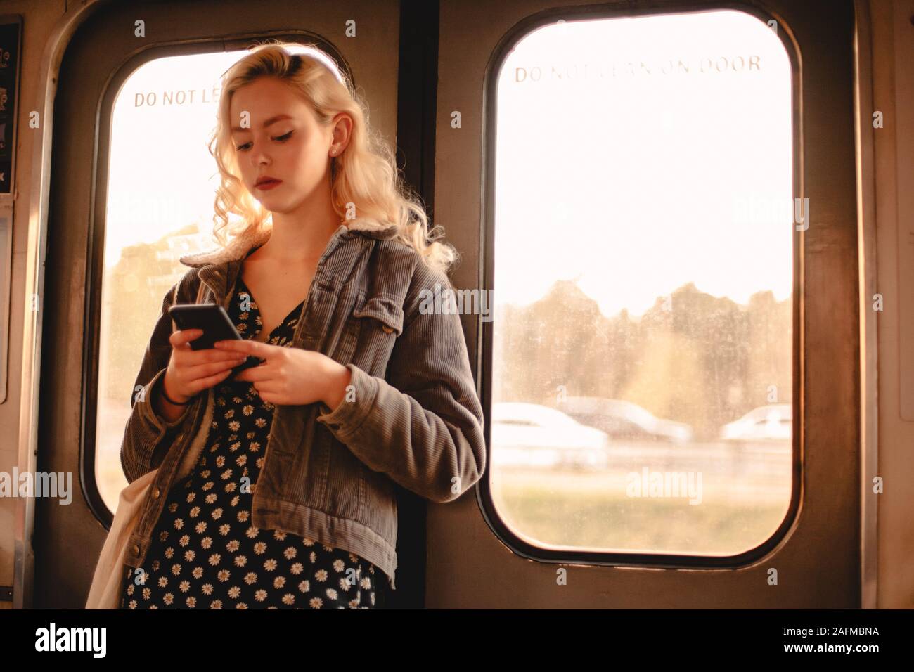 Jeune femme à l'aide de smart téléphone portable en voyage en métro Banque D'Images
