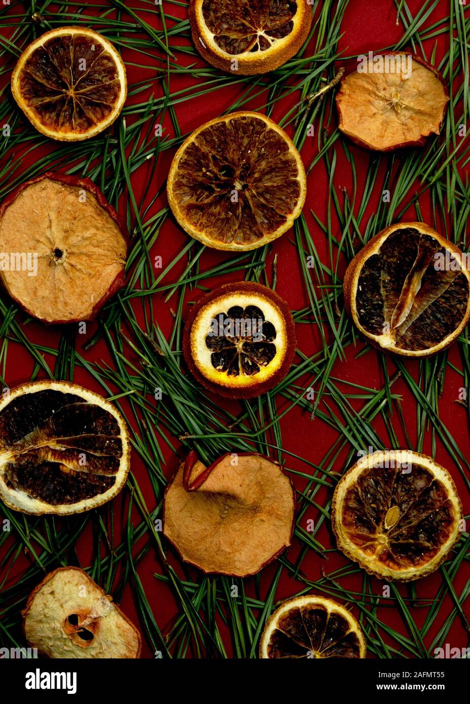 Fond rouge avec des aiguilles de pin et sécher les oranges. Bonne année et composition de Noël. La couleur à la mode. Copier l'espace. Banque D'Images
