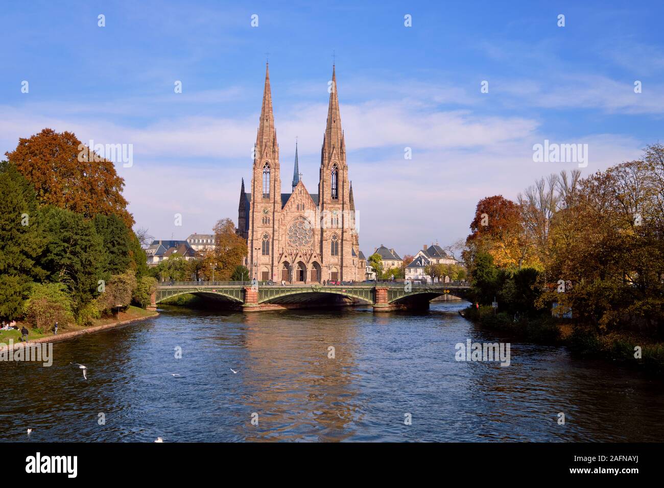 L'église Saint Paul le long de la rivière Ill en plein centre de Strasbourg le long d'une journée d'automne, avec des arbres sur les banques Banque D'Images
