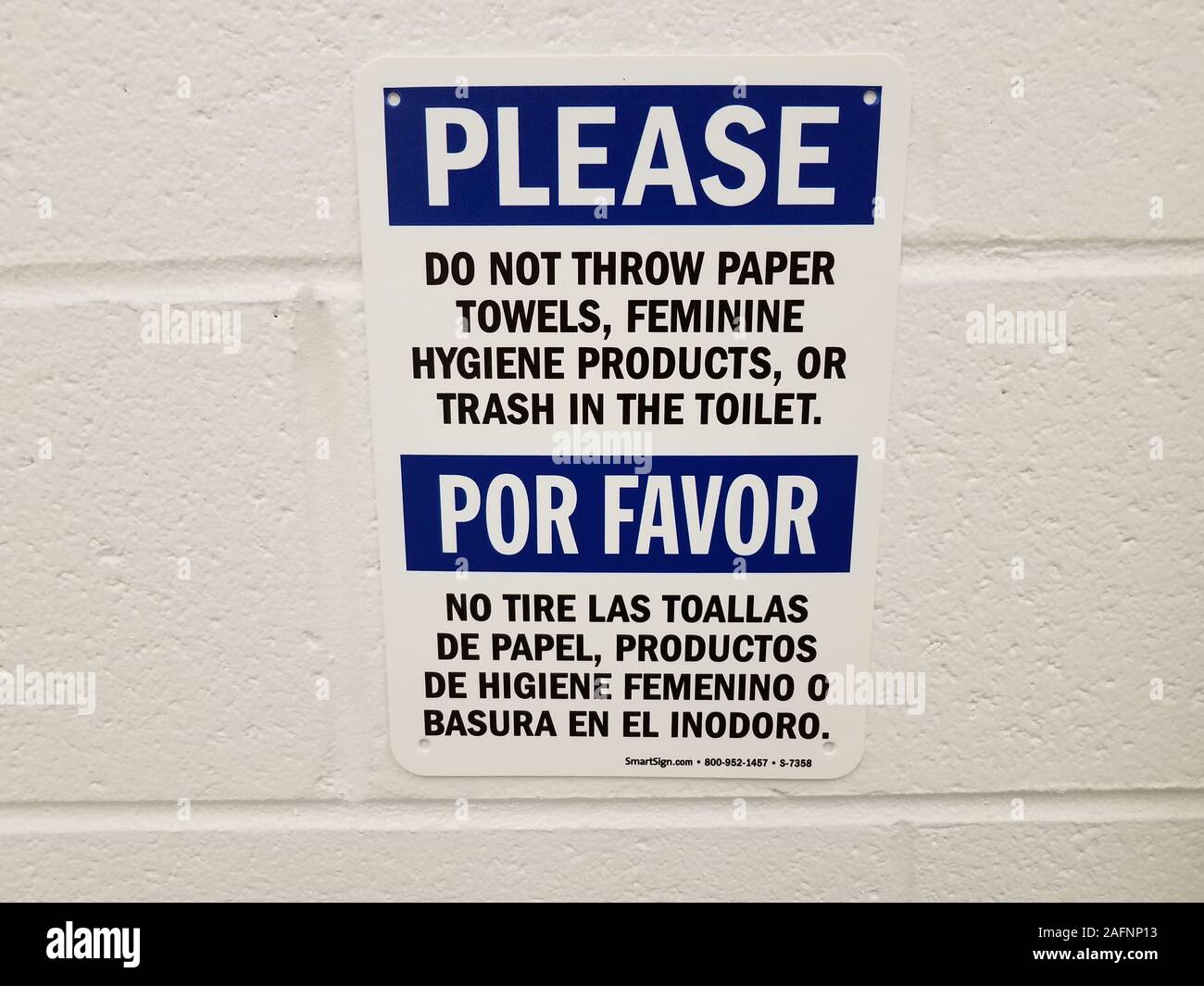Merci de ne pas jeter les serviettes de papier toilettes à signer en anglais et espagnol sur le mur des toilettes ou salle de bains Photo Stock -