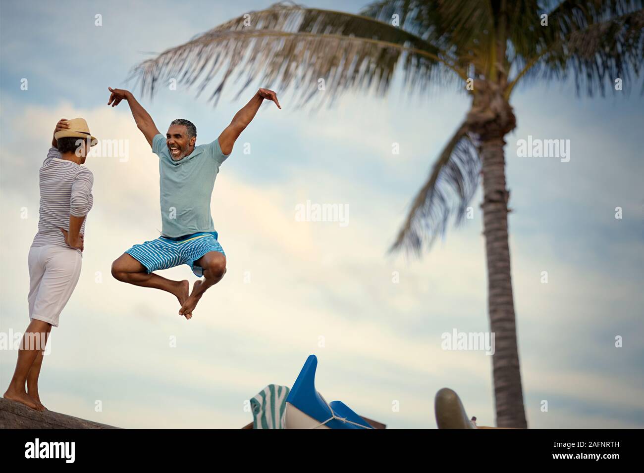D'âge mûr pour rire, sauter et faire des mouvements de karaté sur la plage. Banque D'Images