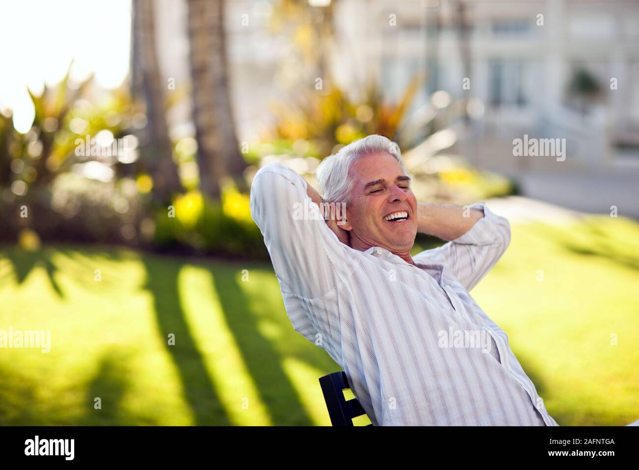 Homme mature jouit d'assis en face de son hôtel. Banque D'Images