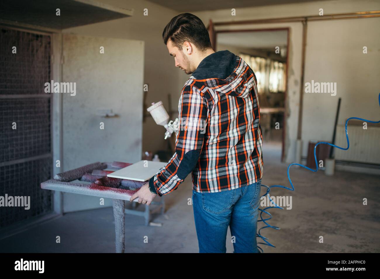 Sprey meubles peinture artisan dans son atelier. Banque D'Images