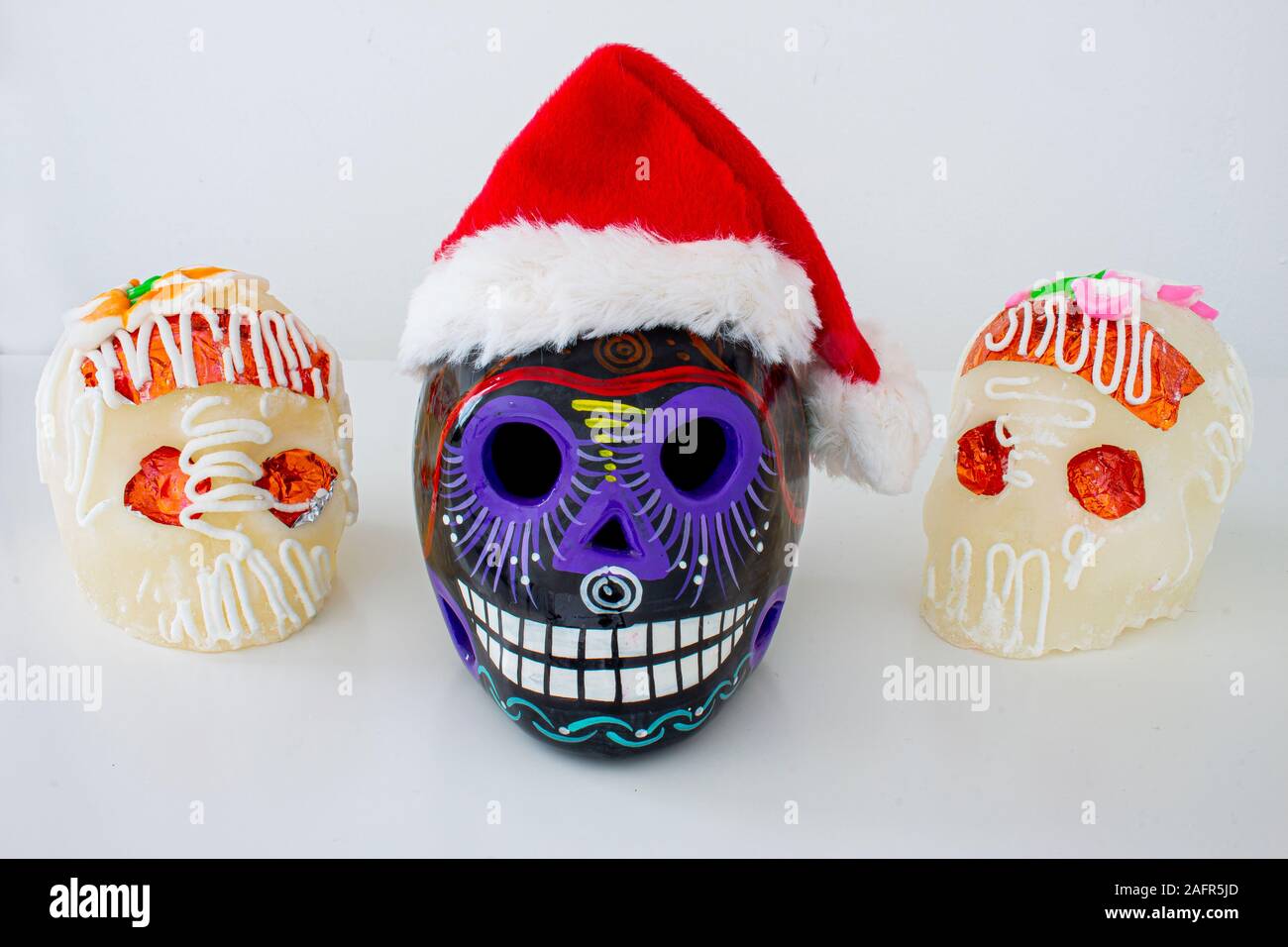 Un sucre mexicain traditionnel noir crâne à Santa hats. Noël mexicain.(calaveritas de azucar para navidad en México) mélanger les cultures. Banque D'Images