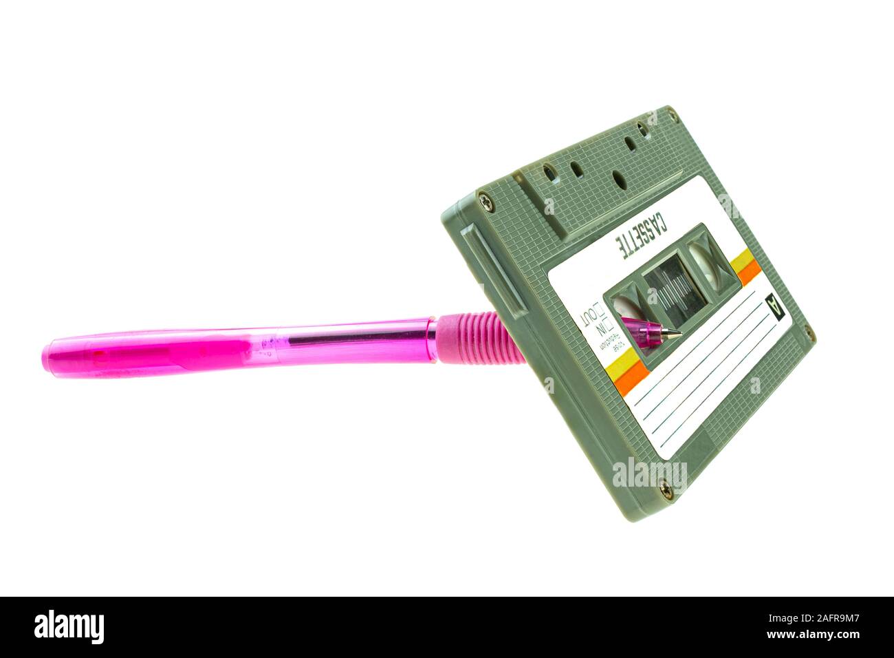 Un stylo rose et compact cassette retro sur fond blanc Banque D'Images