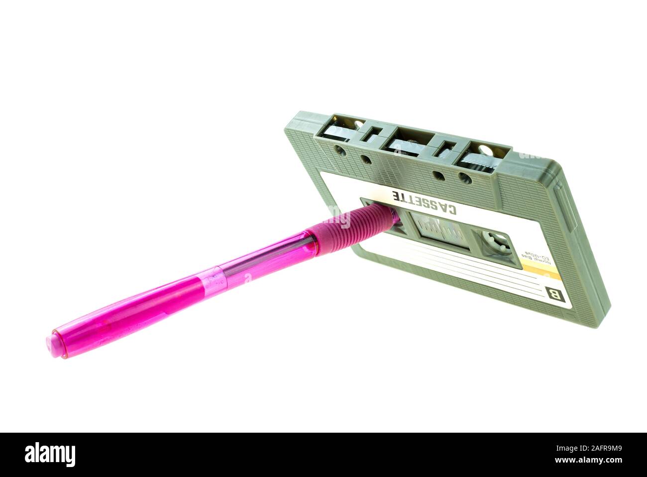 Un stylo rose et compact cassette retro sur fond blanc Banque D'Images