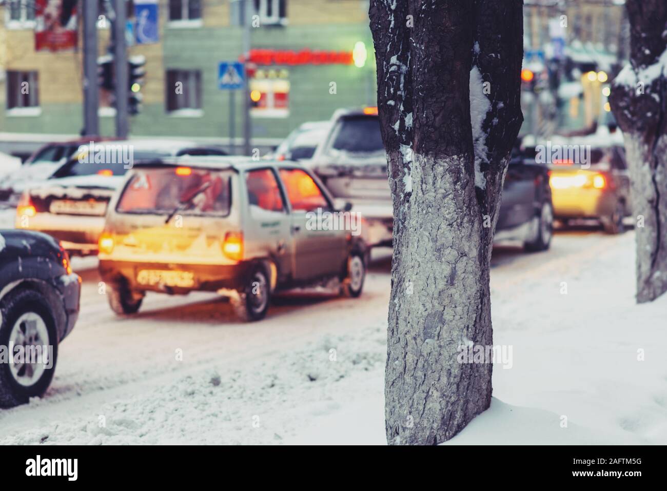 Automobiles sur une route enneigée dans la soirée en Russie Banque D'Images