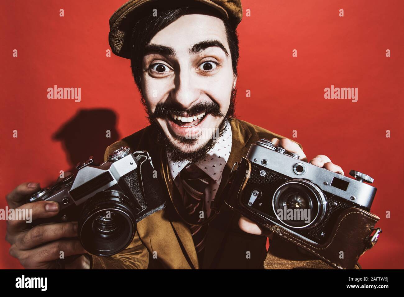 Photographe très positive qui pose en studio, avec un appareil Banque D'Images