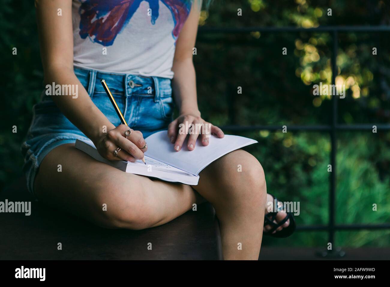 Jeune femme écrivant dans le journal Banque D'Images