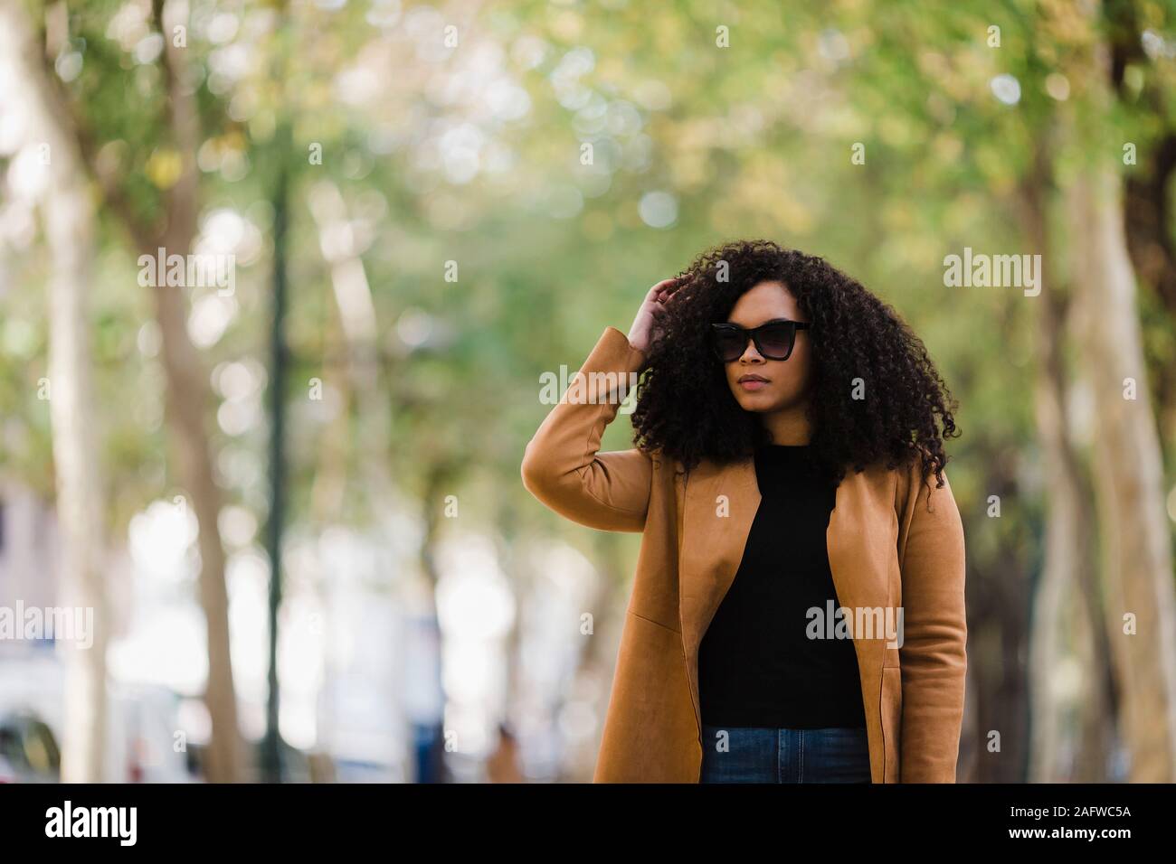 Jeune femme élégante en lunettes walking in park Banque D'Images