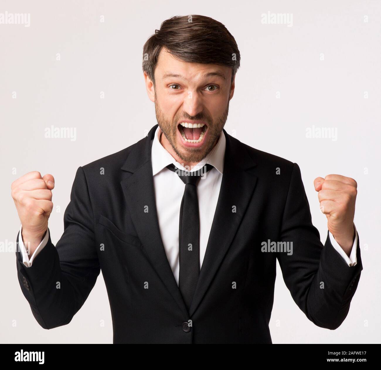 Homme d'émotionnel en criant et agitant les poings on White Background, Studio Banque D'Images