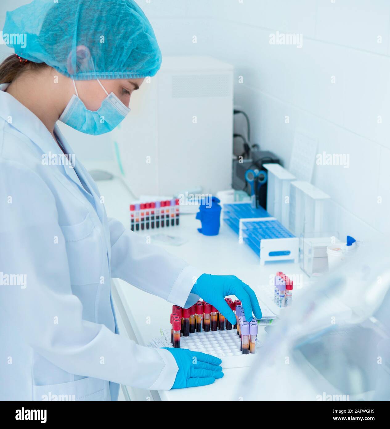 Masque de femme dans la mise en tubes à essai avec du sang pour les tests Banque D'Images