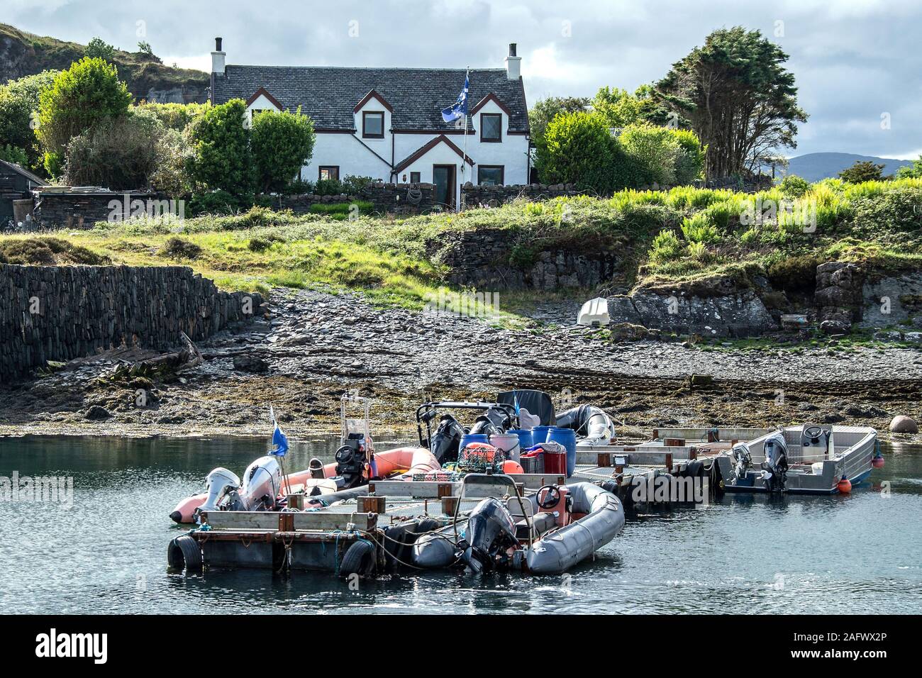 Les petits bateaux amarrés dans le port abrité sur Easdale Island au large de la côte ouest de l'Ecosse. Banque D'Images