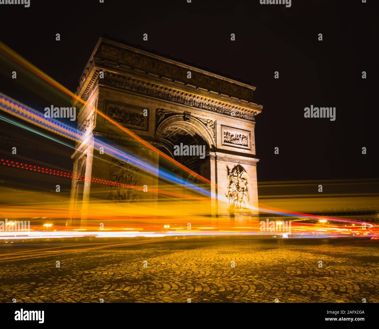Vue à temps de sentiers lumineux autour de l'Arc de Triomphe à Paris, France. Banque D'Images