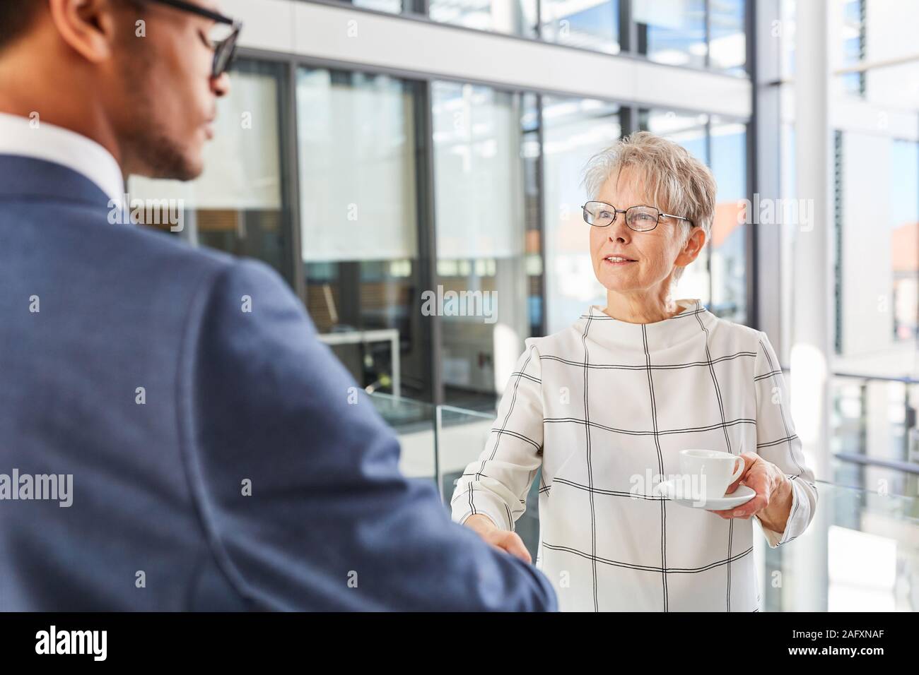 Personnes âgées businesswoman shaking hands with African Business partner Banque D'Images