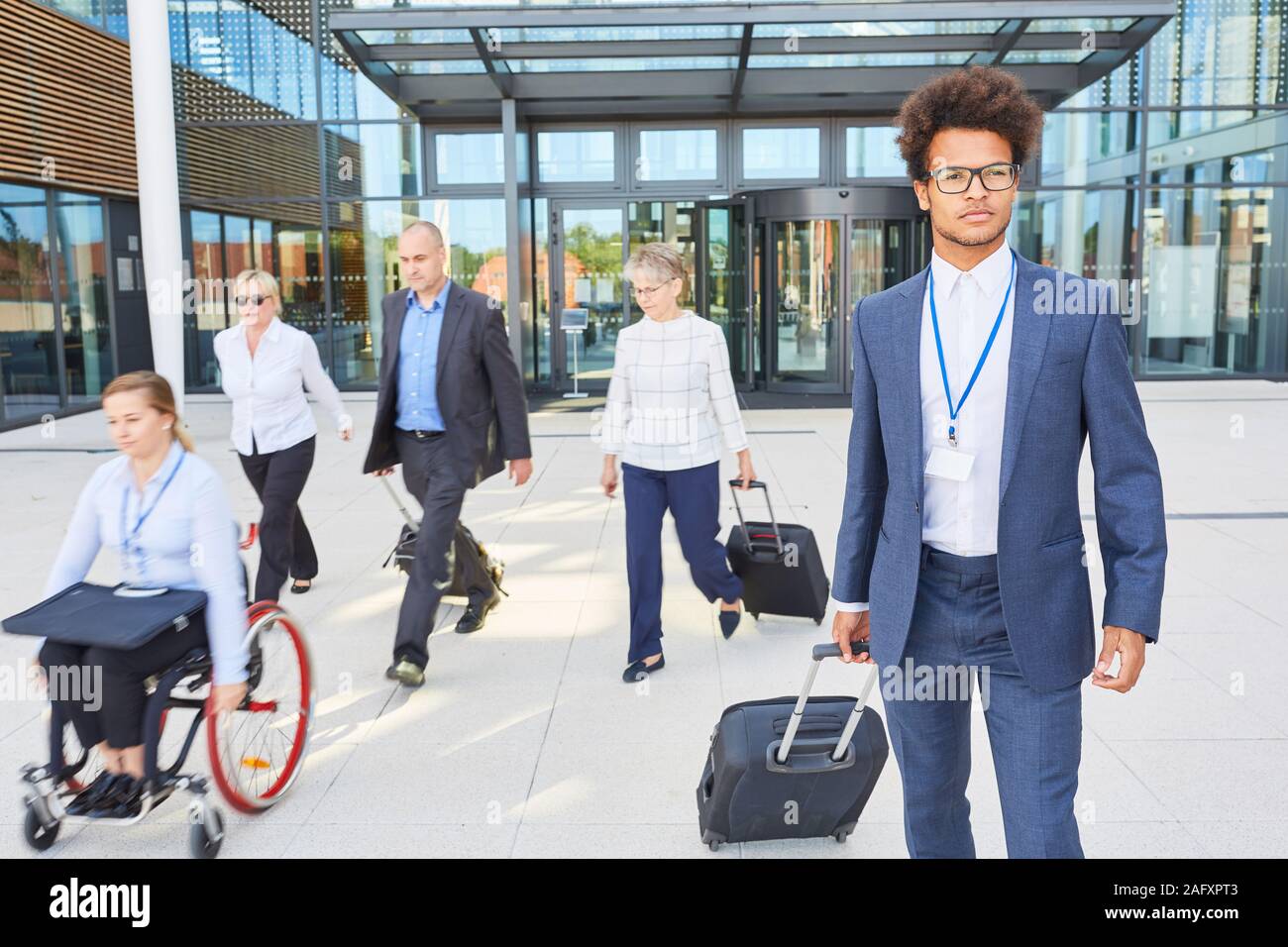 Groupe de gens d'affaires avec un collègue en fauteuil roulant sur un voyage pour l'inclusion Banque D'Images