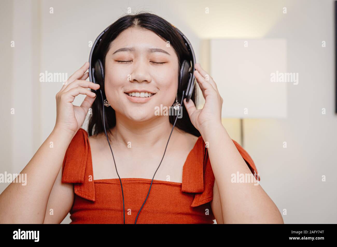 Grosse fille teen profitez de la musique pour écouter sourire intérieur se détendre mentale. Banque D'Images