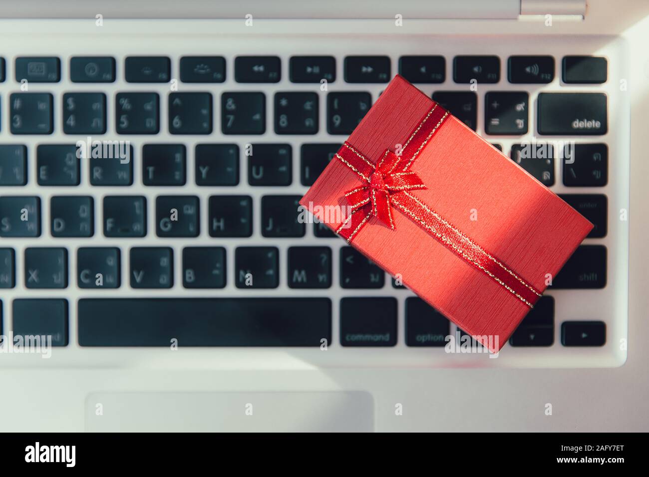 Boîte-cadeau précieux de petits présents sur le clavier de l'ordinateur portable pour nouvel an vendredi noir ou magasinage en ligne concept. Banque D'Images