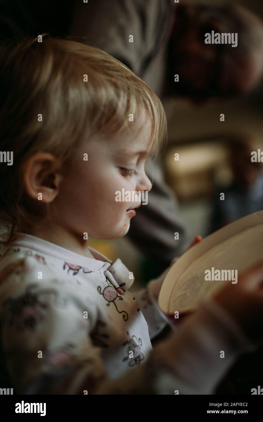 Profil de l'enfant en pyjama à la recherche en haut du récipient de crème glacée Banque D'Images