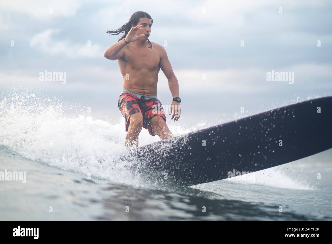 Surfant sur le lever du soleil au Costa Rica Banque D'Images